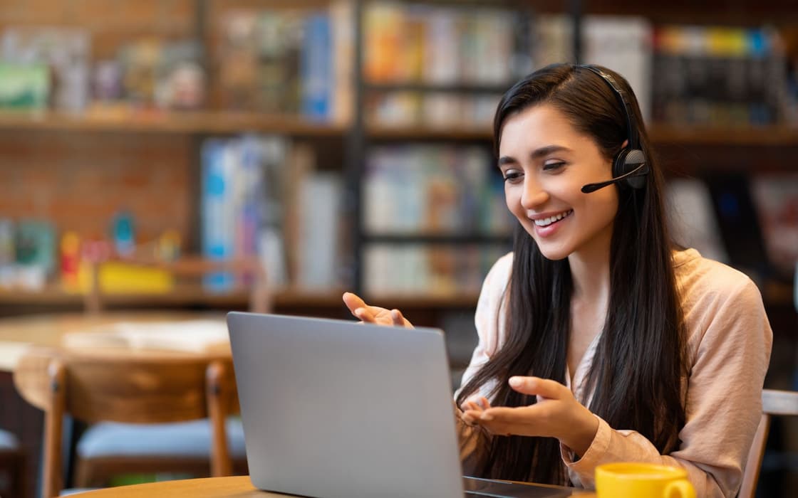 Tutor teaching an online session with a headset and laptop