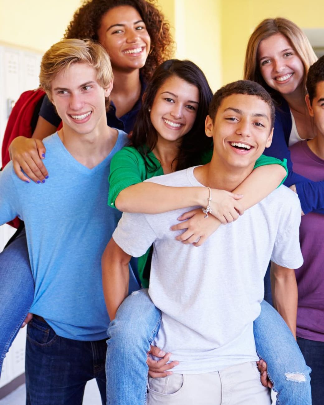 Group of smiling students gathered in the hallway before class