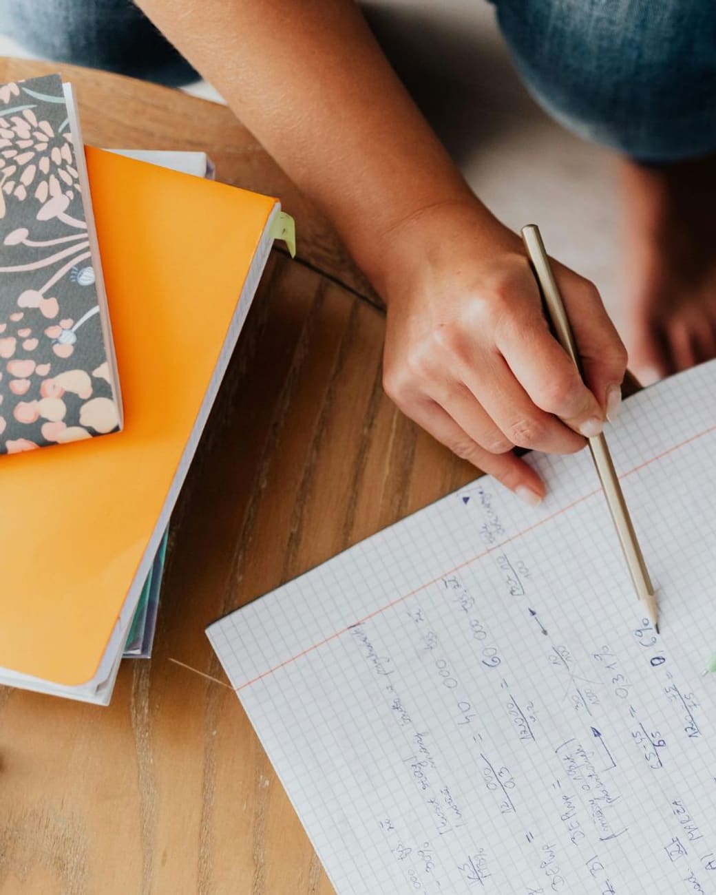 Tutor pointing out the next step in a graph-paper math notebook