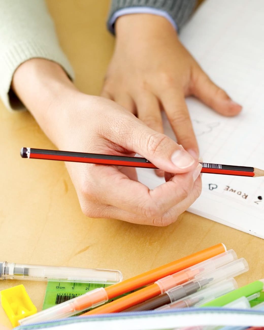 Tutor guiding a young student's handwriting practice up close