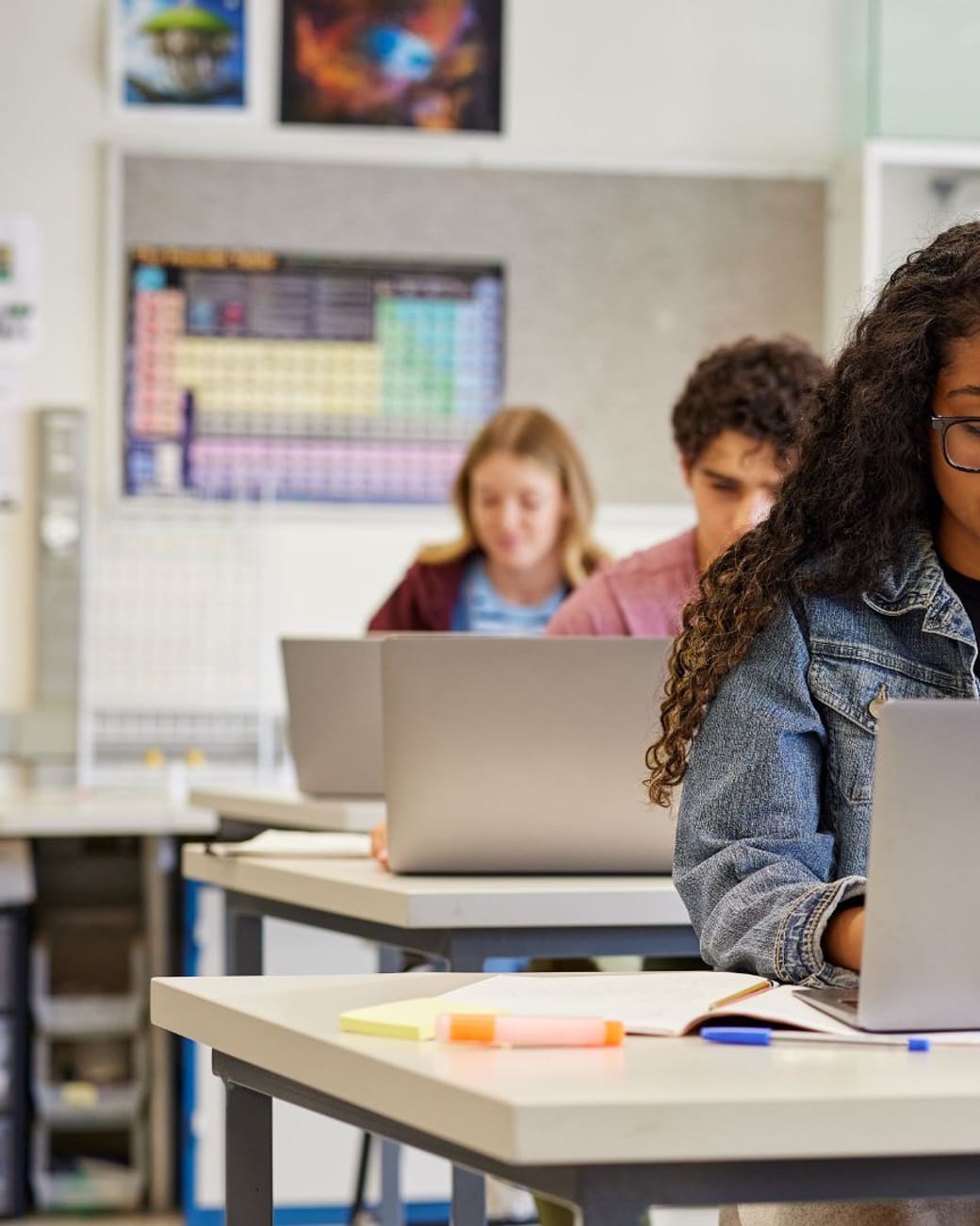 Student joining class from a laptop in a bright classroom